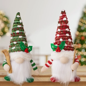 Pair of Christmas gnomes with knitted hats and wooden skis on a wooden table with bokeh lights