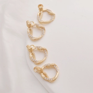 Detailed close-up of 14K gold-plated snake pendants with sparkling cubic zirconia inlay