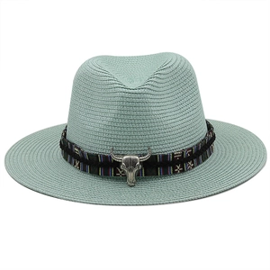 Detail of mint green straw fedora with ethnic woven band and silver bull head charm