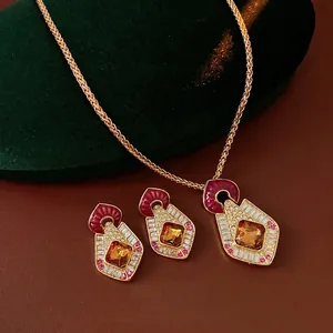 Vintage gold jewelry set with amber gemstones and red enamel on dark leather background