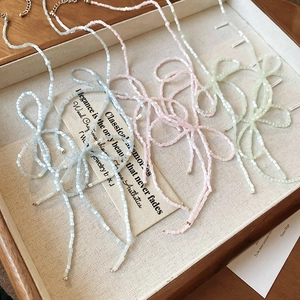 Elegant bow-shaped beaded necklace in pastel macaron colors with metal extension chain