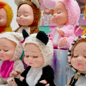 Detailed view of sleeping dolls in plush panda and rabbit outfits with safety packaging