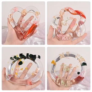 Macro detail of handmade resin coaster molds with colorful embedded dried flowers