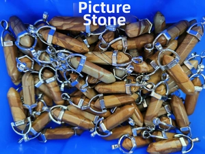 Macro shot of natural picture jasper hexagonal pendants in a bulk storage container