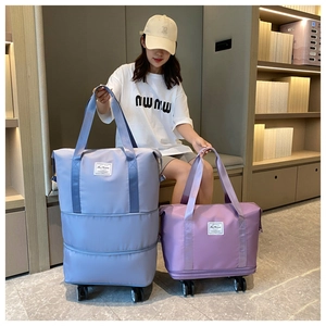Close-up of expandable waterproof travel bags with wheels in light blue and purple colors