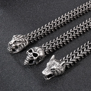 Macro view of retro stainless steel lion, skull and wolf charms on a woven biker bracelet