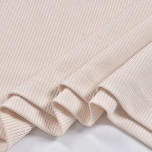 Dettaglio della trama in maglia a coste color albicocca e cuciture dell'orlo