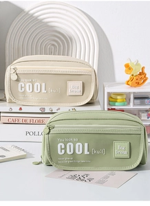 Detail of minimalist beige and green canvas pencil cases with zipper and embroidered patch