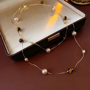 Layered sweater necklace with pink pearls and tiger eye beads on brown leather
