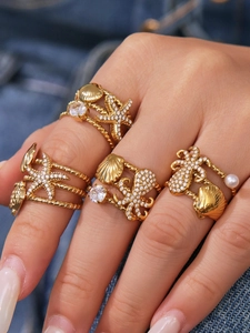 Detail of gold starfish and octopus wrap rings with zircon stones and a white pearl