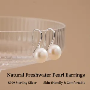 Élégantes boucles d'oreilles en argent S999 avec perles d'eau douce sur un verre