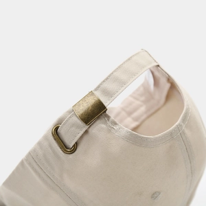 Détail de la boucle en métal réglable sur la casquette de baseball en coton brodé beige
