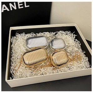 Detail view of gold and silver metallic textured mini bags with chain straps in a gift box