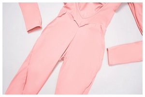 Detailed flat lay of pink long-sleeve yoga bodysuit with V-neck and ergonomic seams