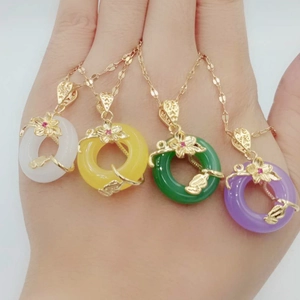 Detail view of four colorful pingan kou pendants on golden necklaces with flower charms