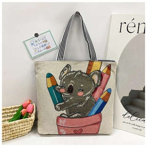 Detailed view of canvas tote bag featuring cute cartoon koala print and striped handles