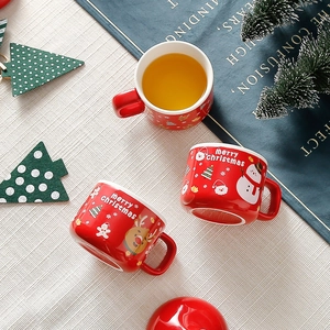 Top-down view of Christmas ceramic mugs with Santa Claus patterns and festive red glaze