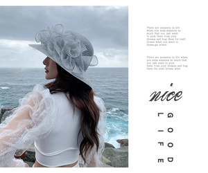 Detail of grey wide brim sun hat with organza floral accent and beach backdrop