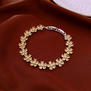 Détail du bracelet fleuri en argent avec zircon jaune sur fond de velours rouge