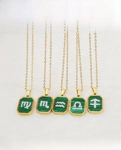 Macro shot of 18K gold plated stainless steel necklaces with malachite zodiac pendants