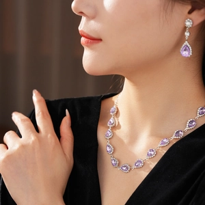 Detail of luxury silver set with pear-shaped purple stones and small clear diamonds