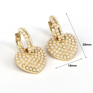Detail view of heart-shaped gold earrings with inlaid pearls, 28mm height and 18mm width