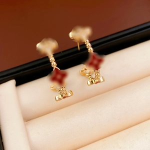 Close-up of 18k gold plated flower stud earrings with red petals in a jewelry box
