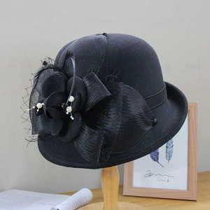 Chapeau cloche élégant en laine noire avec fleurs et perles sur support bois