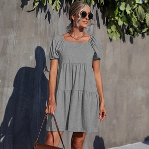 Minimalist grey short-sleeve tiered dress for women in soft knitted fabric outdoor view