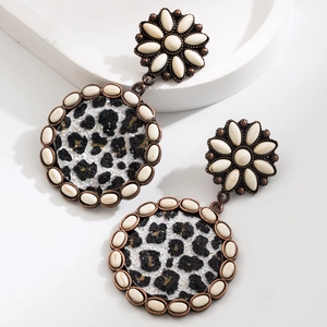 Detail of bohemian drop earrings with leopard print and white cabochon daisy accents