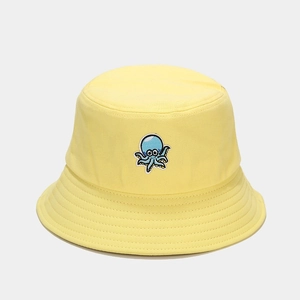 Détail d'une jolie broderie de poulpe bleu sur un chapeau bob en coton jaune