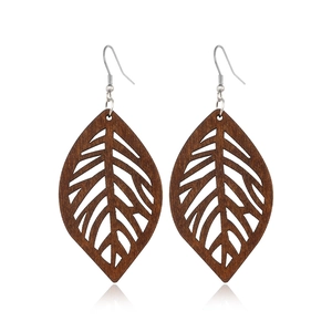 Detailed view of dark brown wood hollow leaf earrings with silver metal hooks on white background