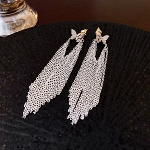 Détail de boucles d'oreilles nœud papillon avec longues franges et zircons brillants