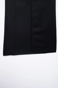 Primer plano detallado que muestra las costuras finas y el dobladillo del vestido negro