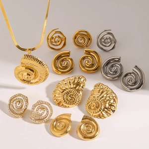 Gold seashell necklace and spiral earrings set with zircon accents on white backdrop