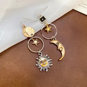 Orecchini pendenti asimmetrici sole e luna con nappe e texture in metallo celeste