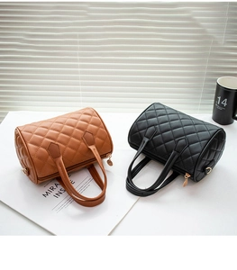 Detailed view of quilted Boston bags with gold hardware in tan and black colors