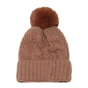 Close-up of brown chunky cable knit beanie featuring a large faux fur pom-pom detail