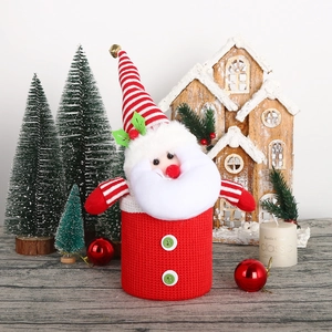 Christmas Santa candy jar with red knit base and striped bell hat on wooden surface