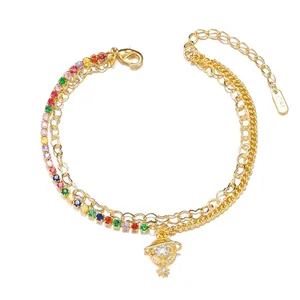 Detail of double-layer gold bracelet with colorful zircons and Saturn-shaped pendant