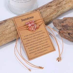 Detalle de tres pulseras de piedra de sol en tarjeta con fondo de madera natural