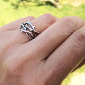 Dettaglio di un anello in argento a forma di ramo di spine dal design punk minimalista