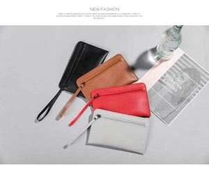 Flat lay of four colorful PU leather zip clutches with wrist straps and textured finish