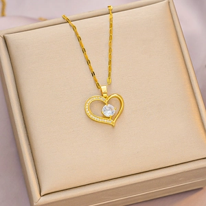 Elegant gold heart pendant necklace with shimmering zircon on golden satin gift box