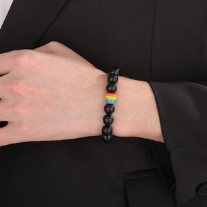 Bracciale minimalista con perline nere e pietra arcobaleno al polso del modello