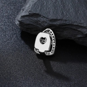 Macro shot of hip hop silver grillz with heart-shaped cutout and black zircon stones