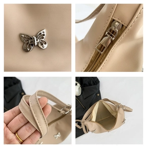 Detail view of beige crossbody bag featuring silver butterfly clasp and interior storage