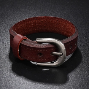 Close-up of reddish-brown leather bracelet with vintage metal buckle and stitching