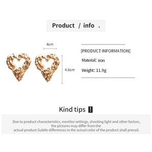 Detail view of gold heart earrings with iron material and weight specifications