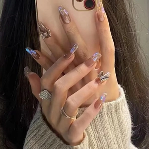 Detailed view of long coffin press-on nails with brown gradient, laser finish and 3D charms